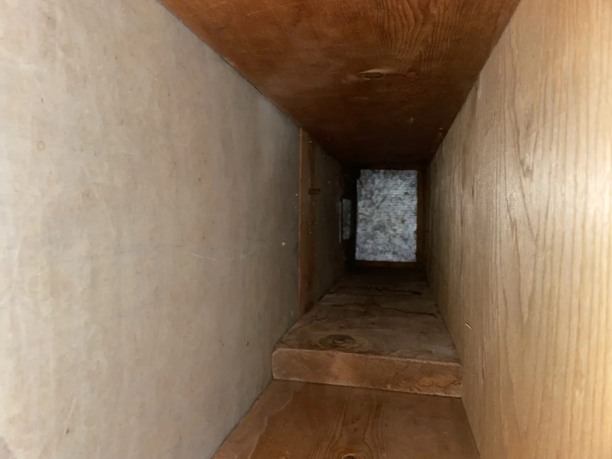 AFTER air duct cleaning: same wood plenum completely clean, bare wood visible
