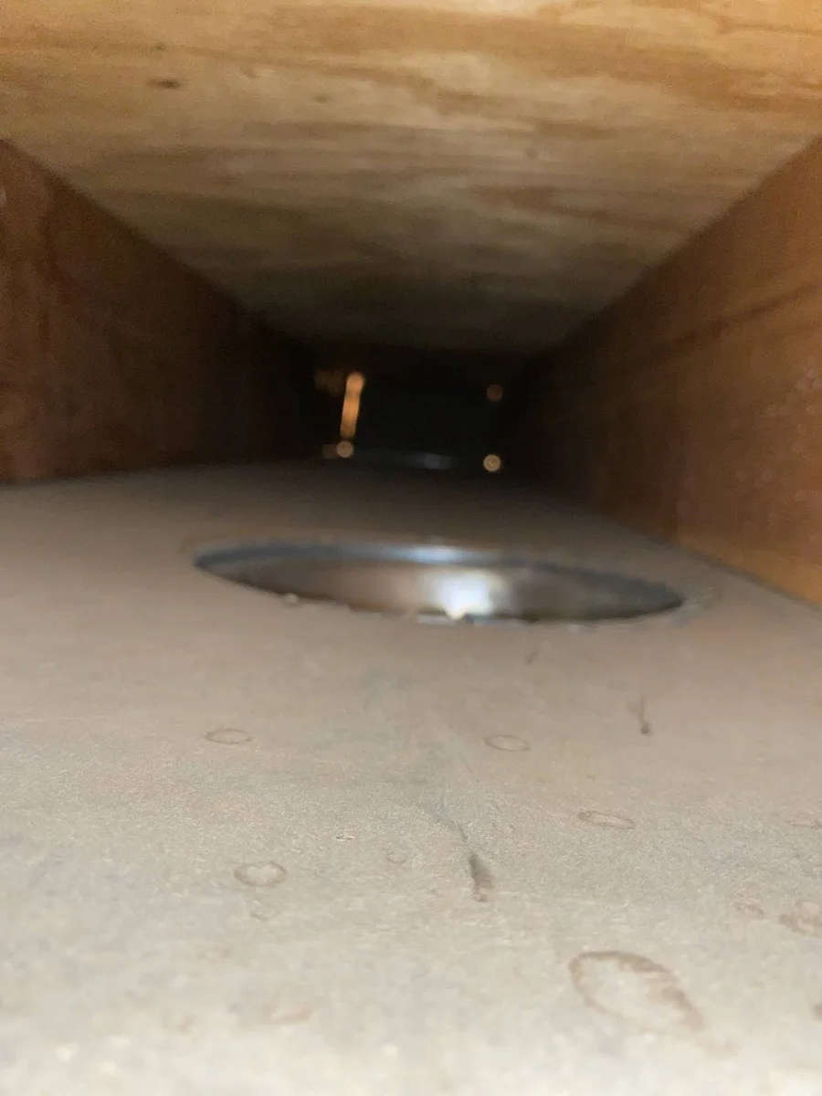 Technician running negative-air duct cleaning equipment