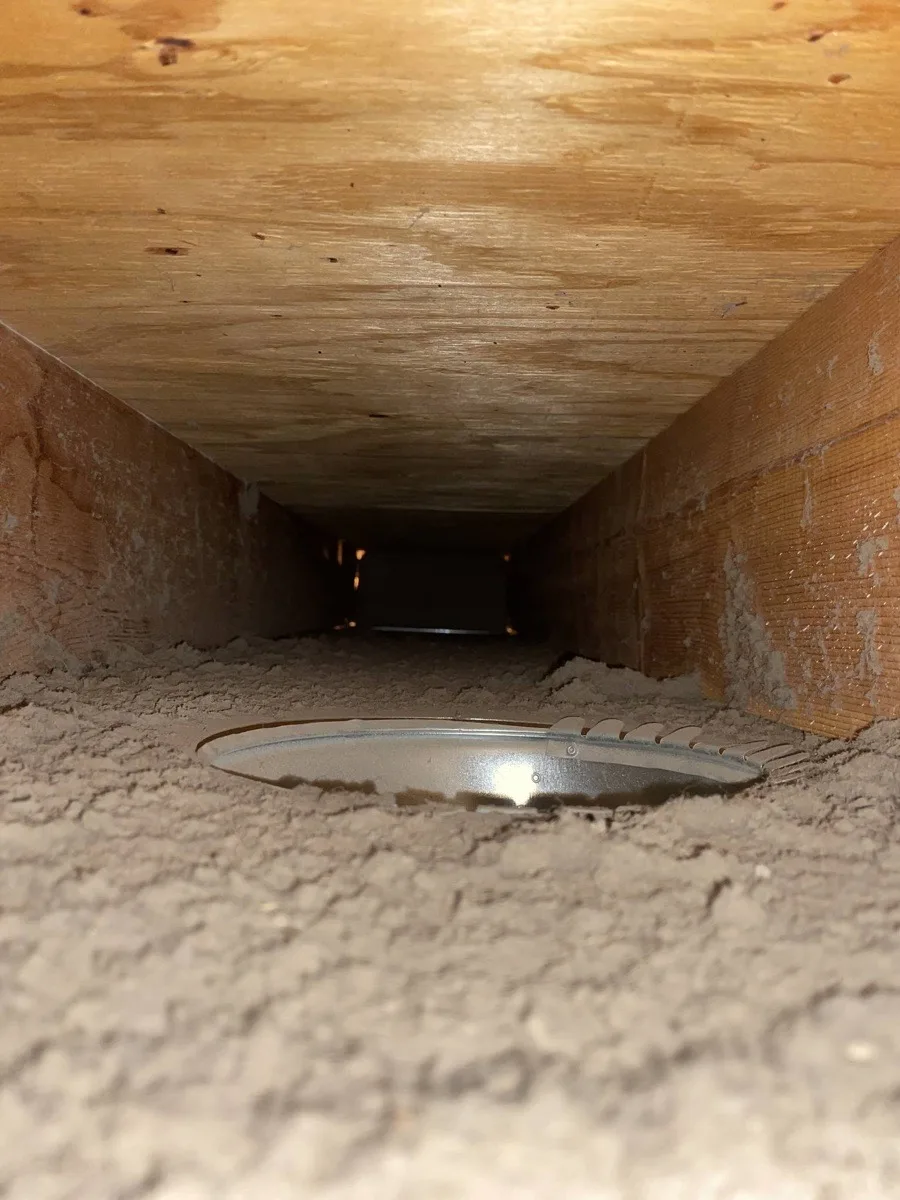 Plenum interior before cleaning — heavy dust and debris buildup