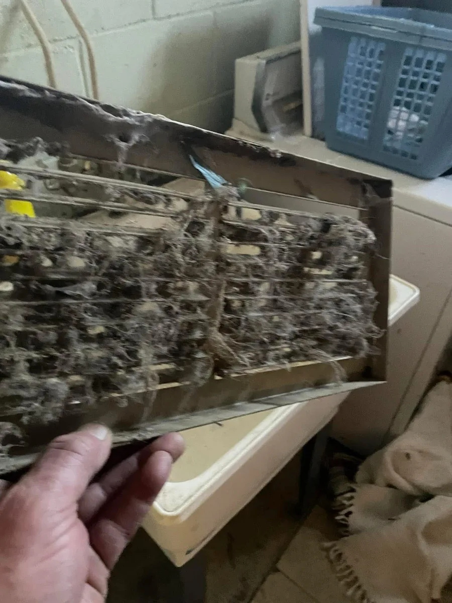 Heavily clogged vent register removed during cleaning service