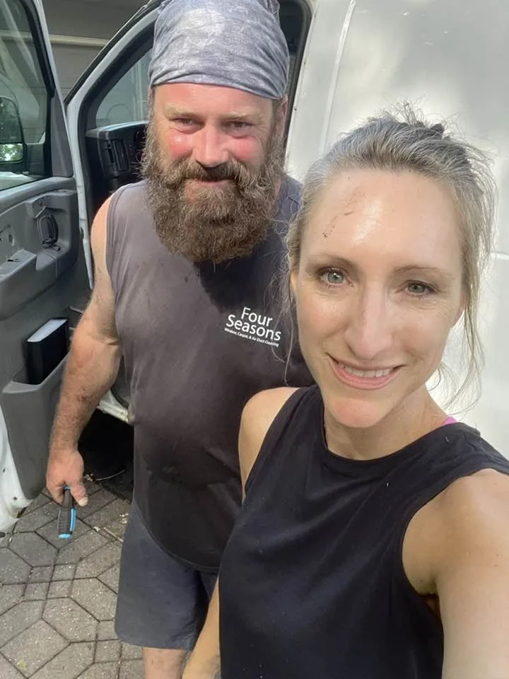 Matt and Carolyn Bertsch after a job, wearing Four Seasons shirts beside the company van